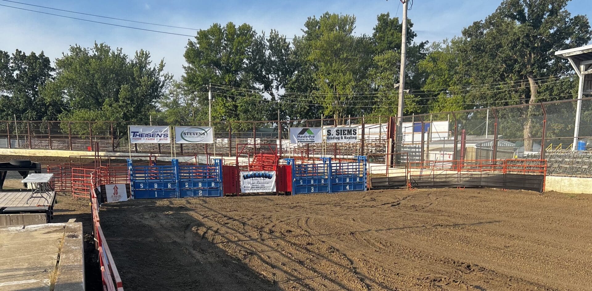 A dirt field with blue and red barriers around it.